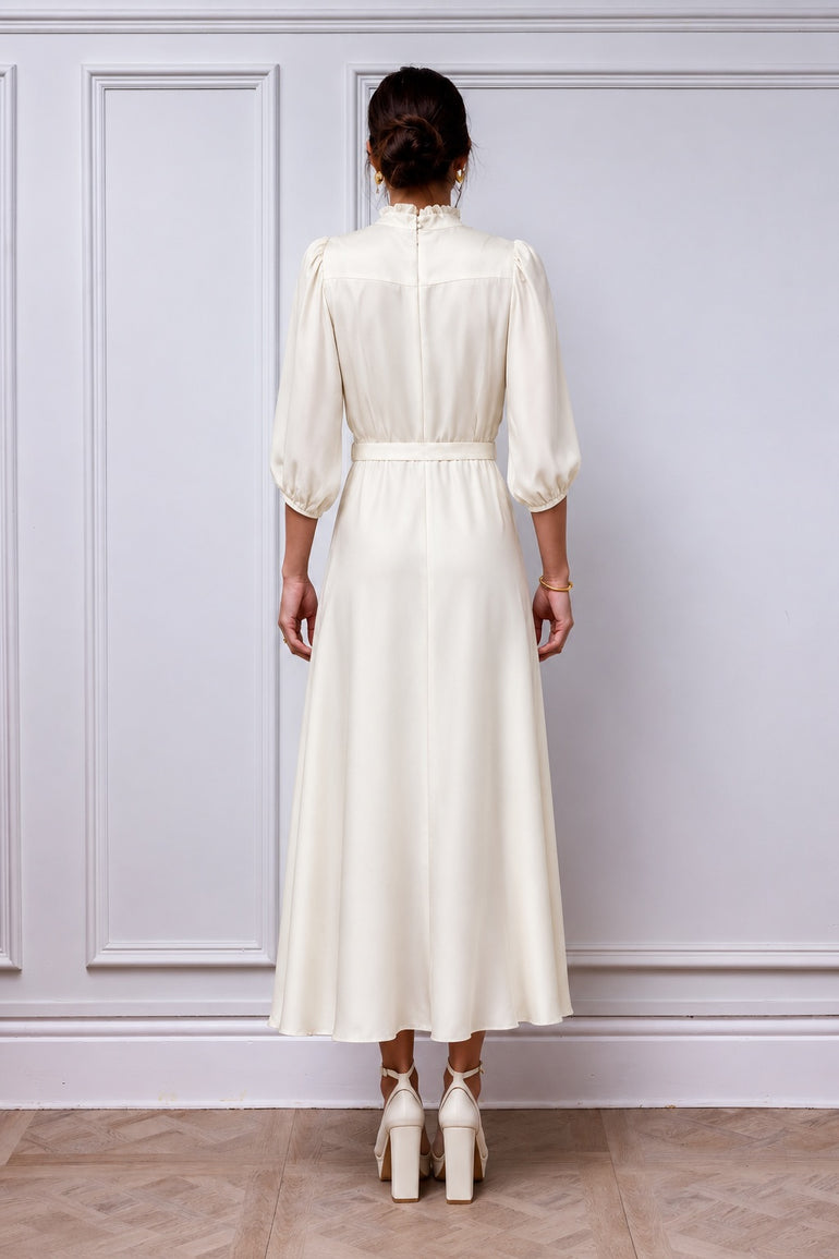 Back view of the Aurelia ivory dress, showing the frill collar, gathered three-quarter sleeves, matching belt and flared skirt.
